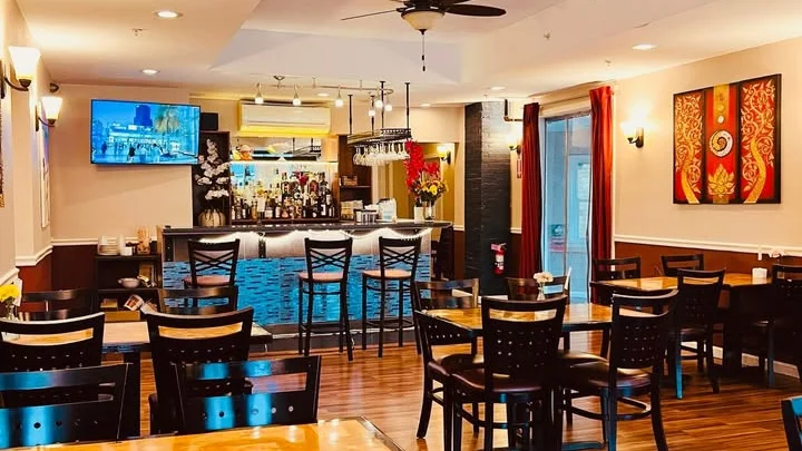 Cozy restaurant interior with wooden tables and bar area