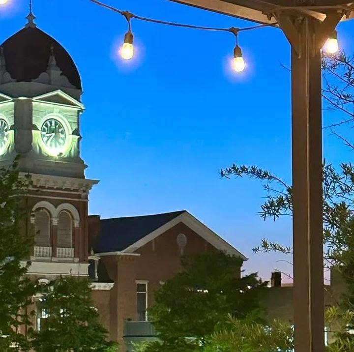 View of a charming town square at dusk with decorative lights