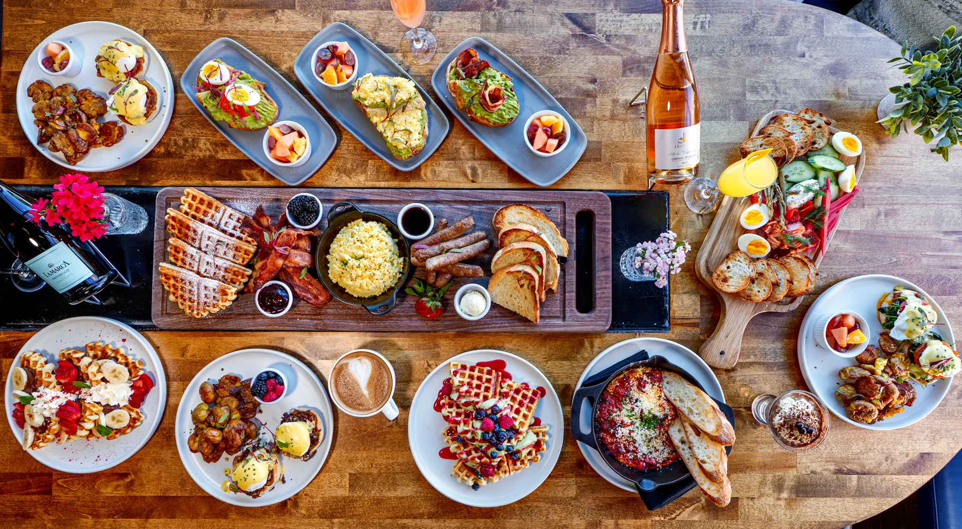 Brunch spread featuring waffles, eggs benedict, and fresh fruit