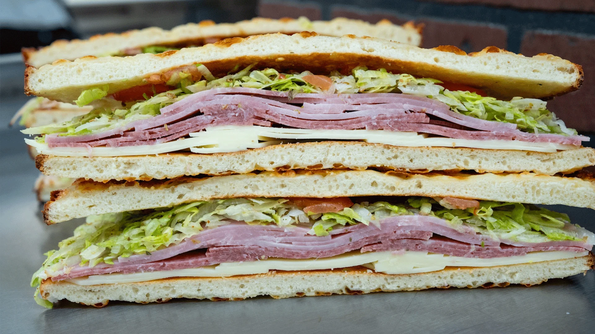 Italian sub sandwich stacked with layers of meats and fresh vegetables