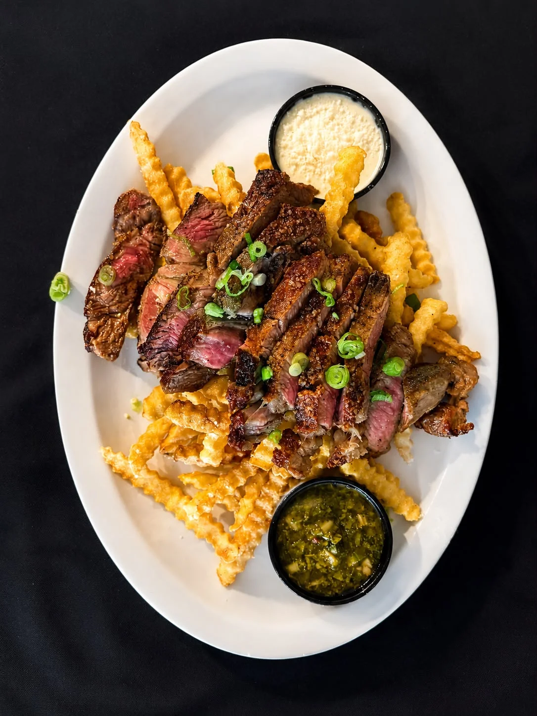 Grilled steak frites served with dipping sauces