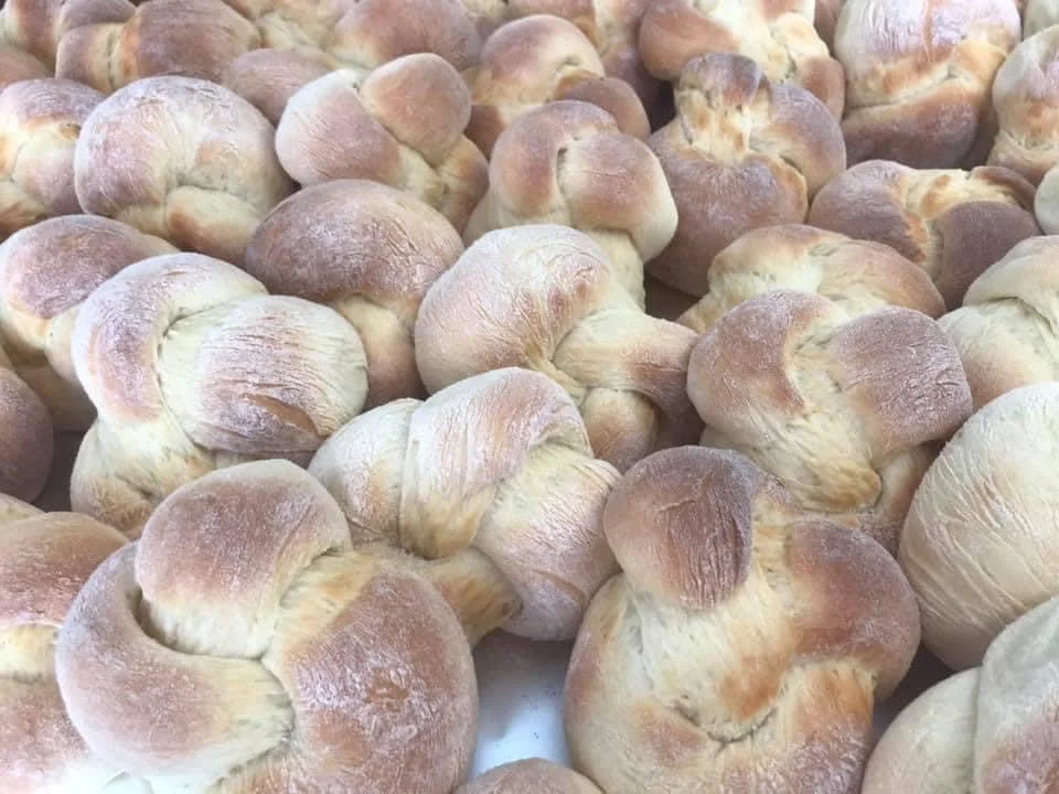 Freshly baked challah bread rolls stacked together