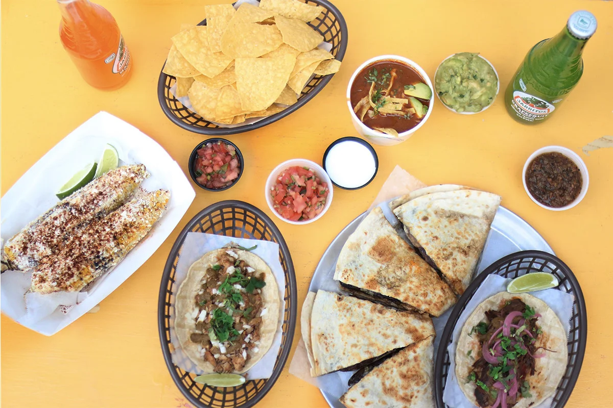 Mexican street food platter with tacos, elote, and guacamole