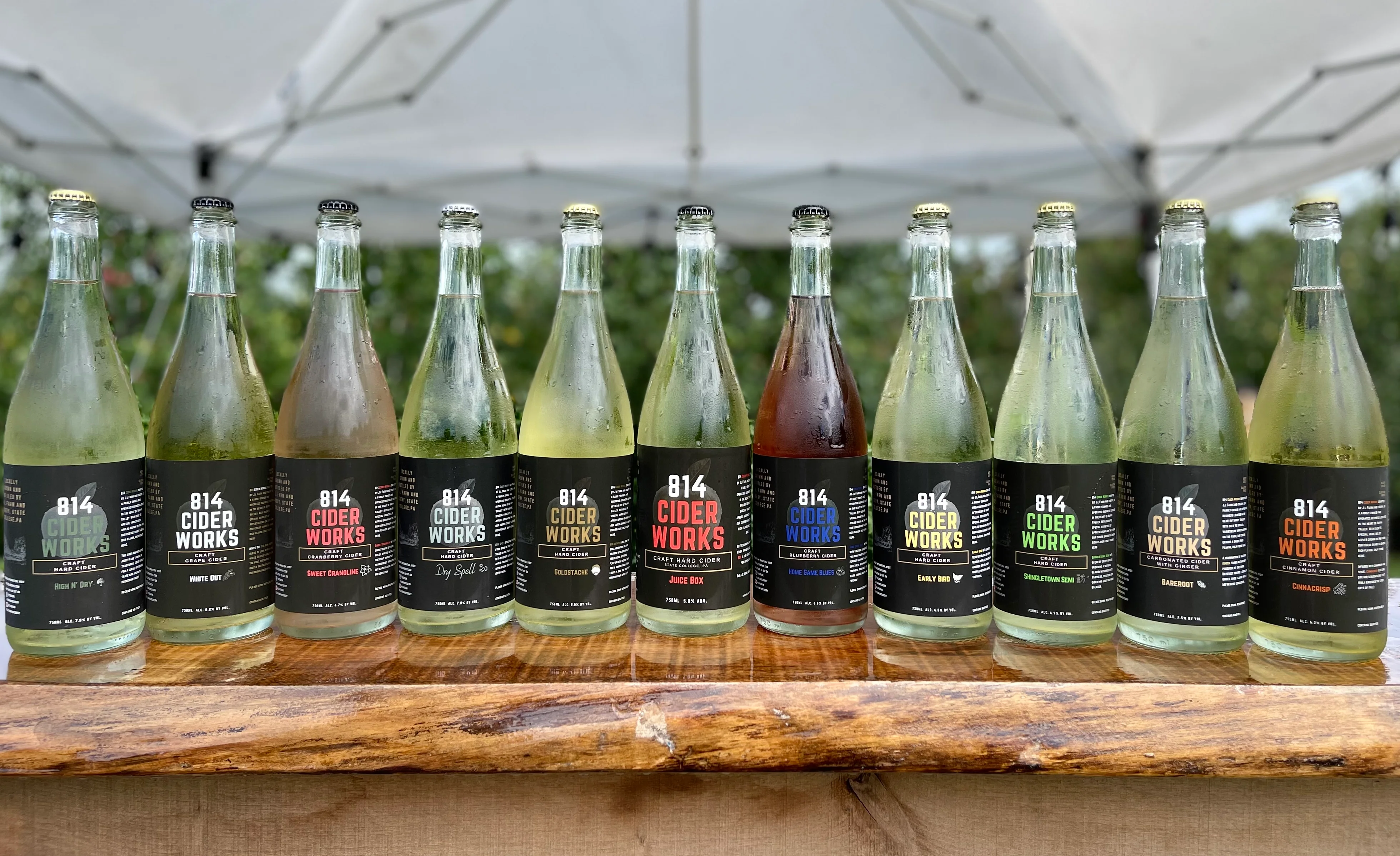 Variety of craft ciders from 814 Cider Works displayed on a wooden table