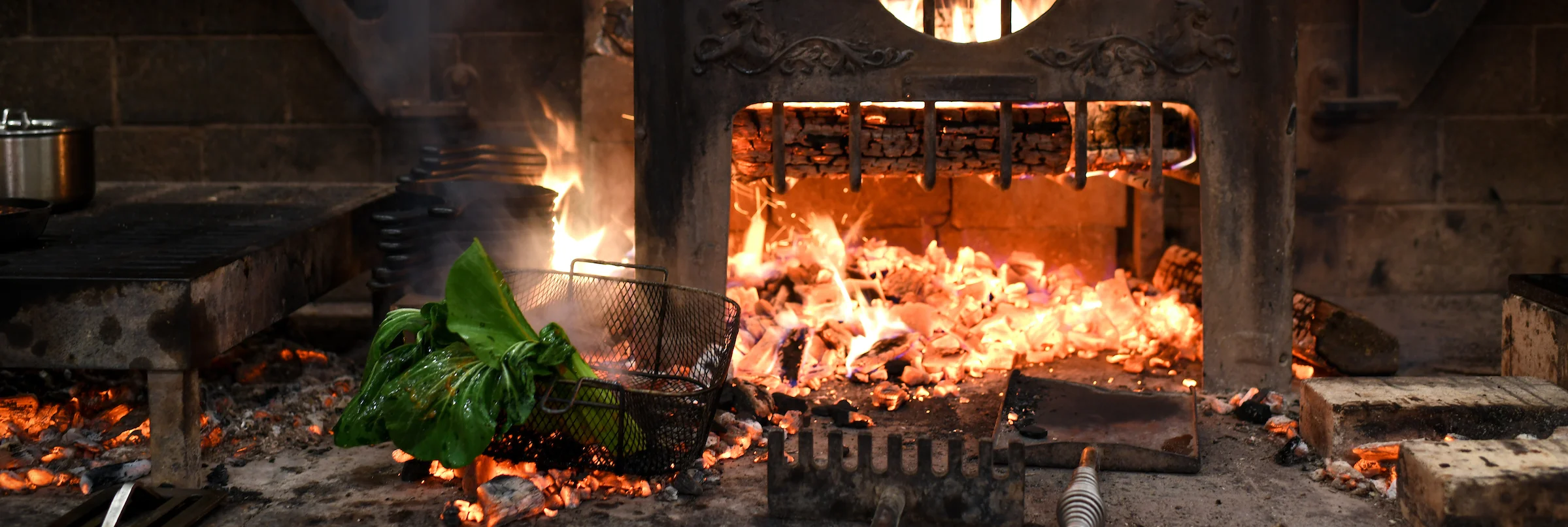 Traditional wood-fired grill with flames and vegetables