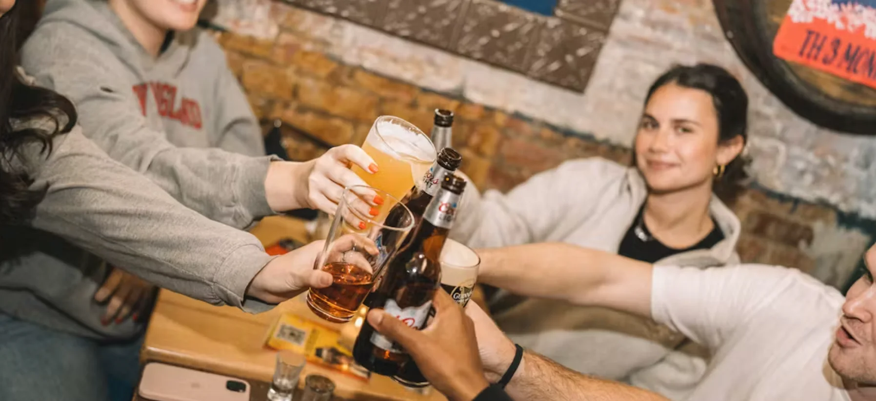 Friends toasting with drinks in a lively bar setting