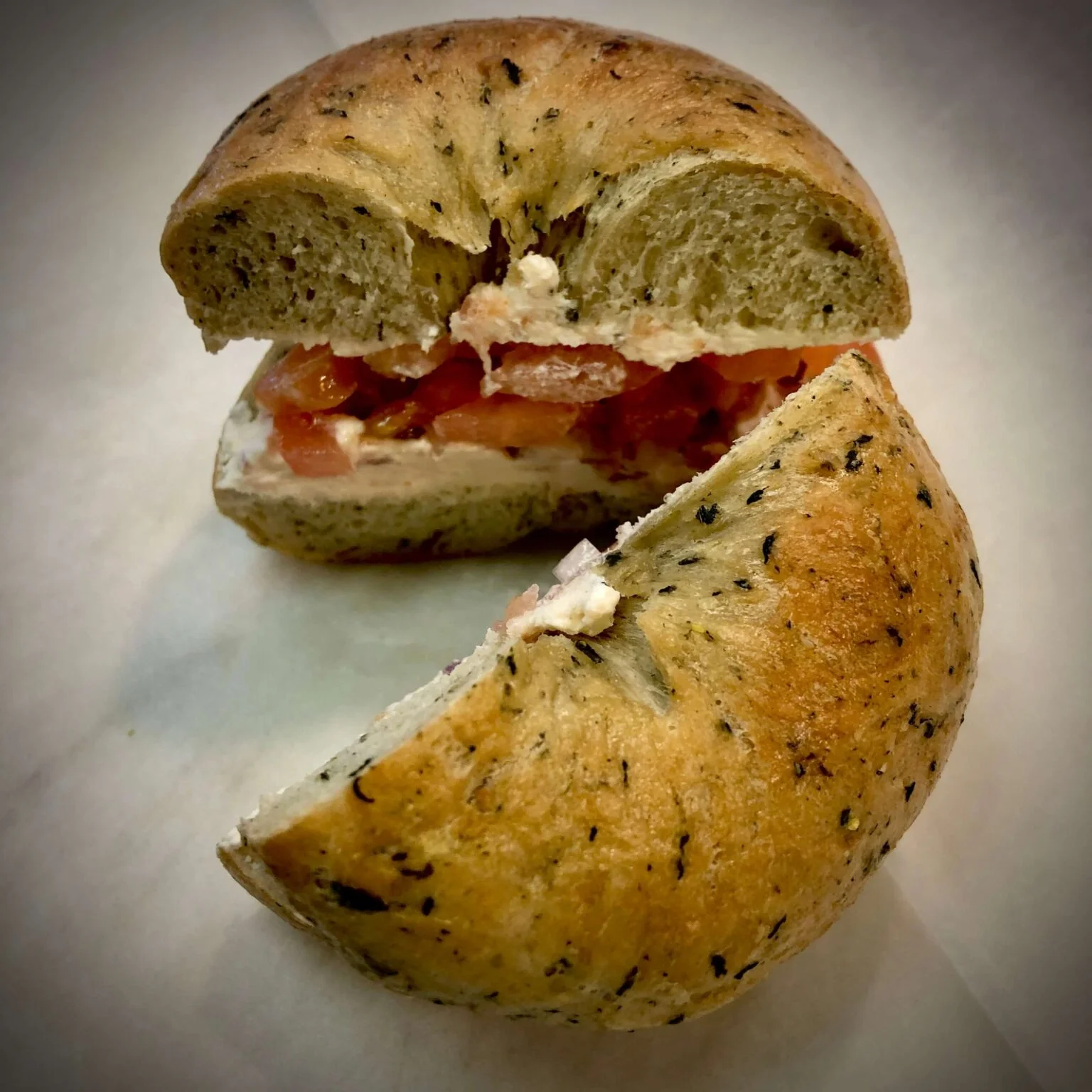 Herb bagel sandwich with cream cheese and tomatoes