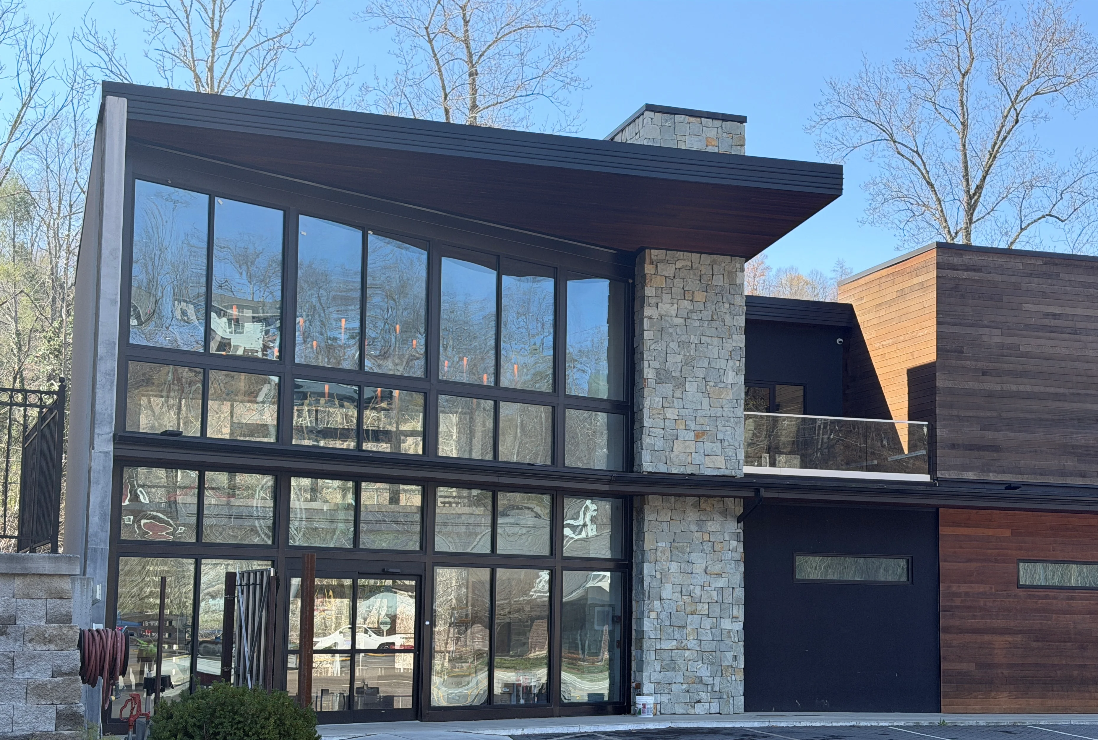 Modern restaurant exterior with large glass windows and stone accents
