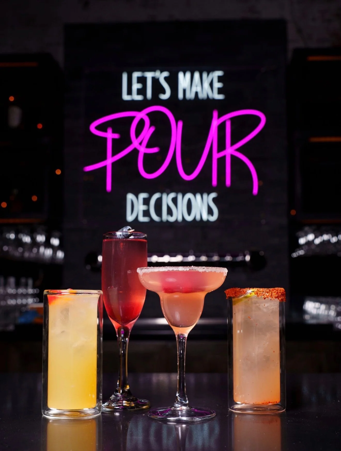 A menu board showcasing the business hours of a lounge and kitchen, featuring vibrant neon signage and a modern bar setting.