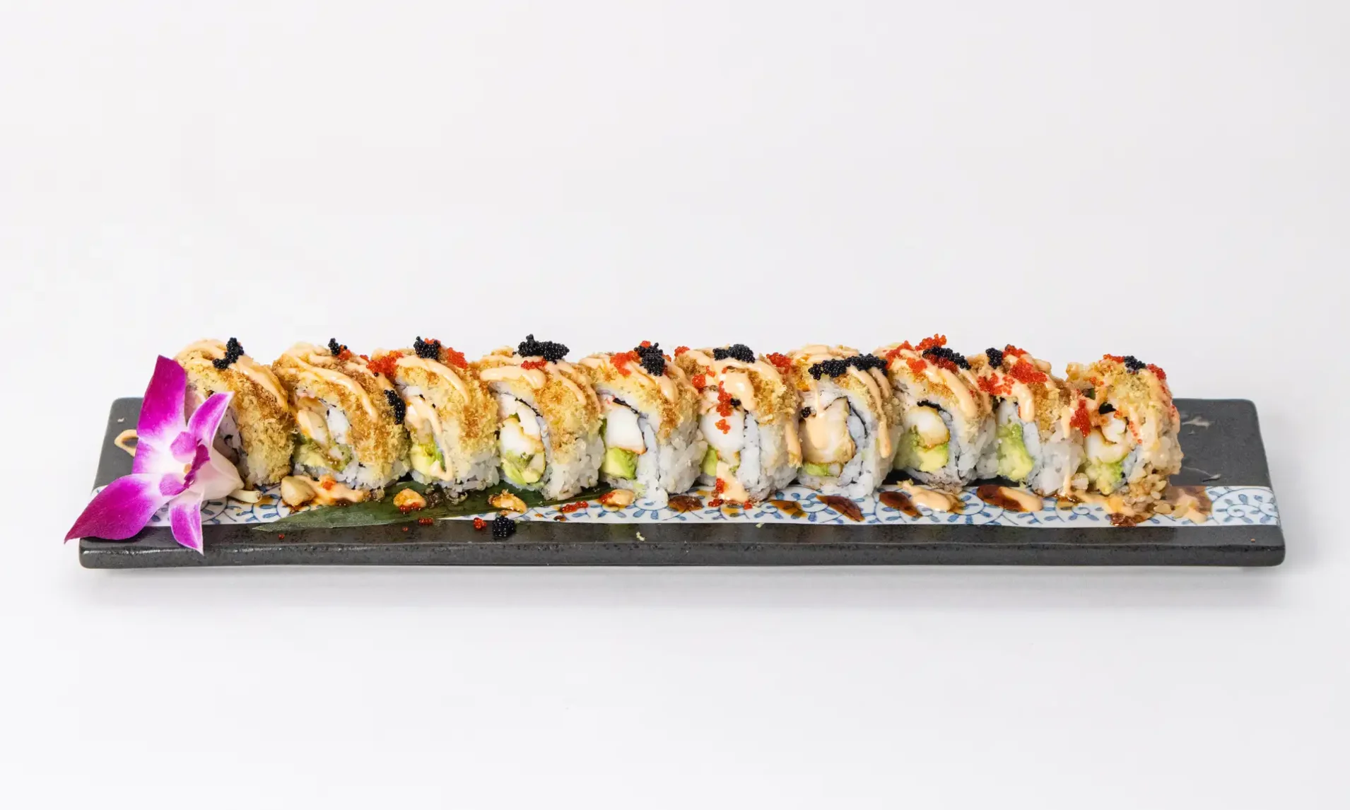 Japanese sushi roll garnished with spicy mayo and caviar