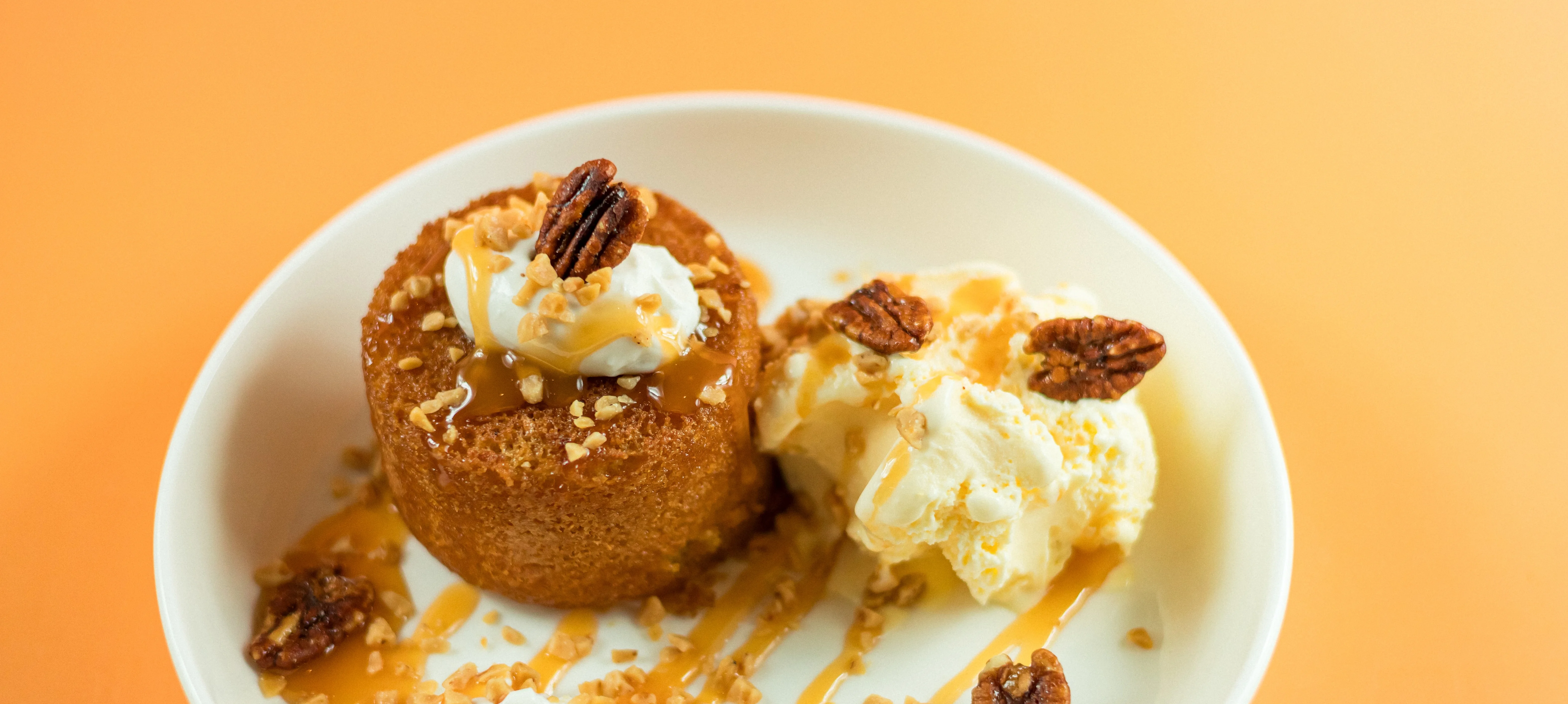 Santorini's brown butter cake dessert topped with vanilla ice cream caramel and pecans