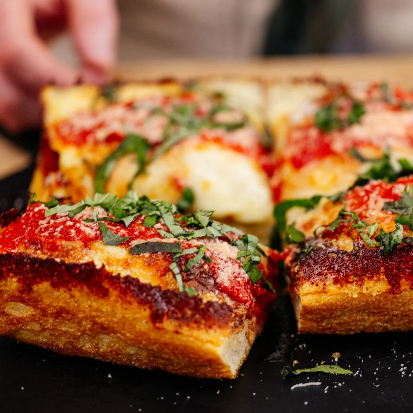 Detroit-style pizza topped with marinara and fresh basil