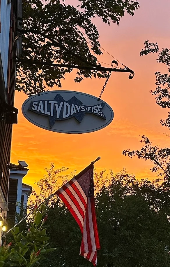 Restaurant sign at sunset with American flag