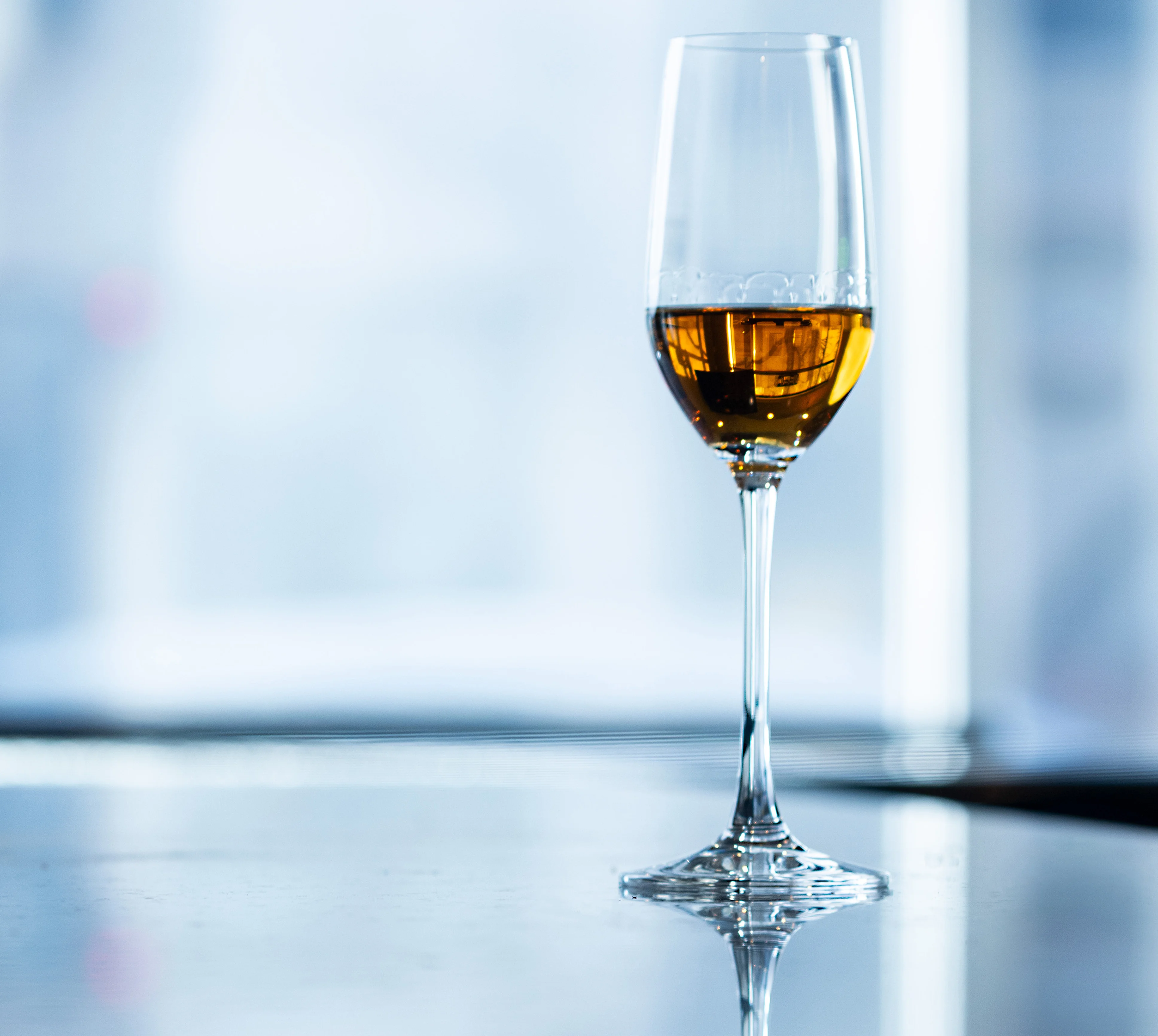 Elegant glass of amber whiskey on a reflective surface