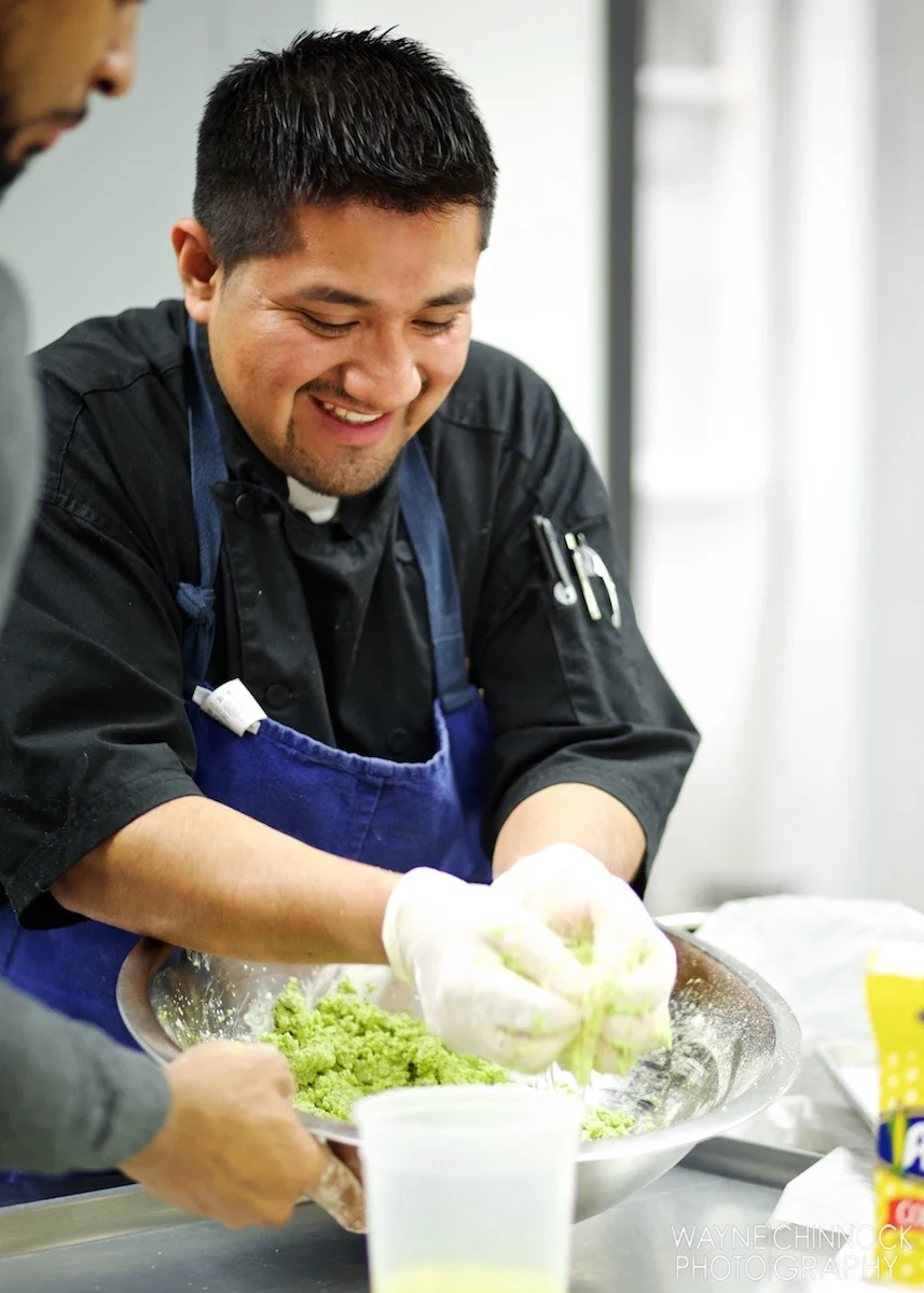 Chef preparing vibrant green dish in a professional kitchen