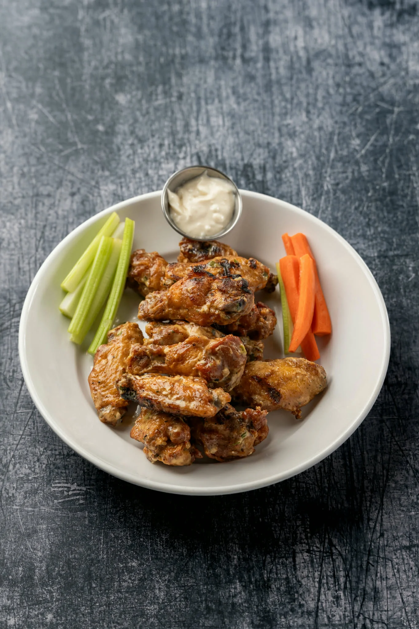 Crispy buffalo chicken wings with celery and carrots