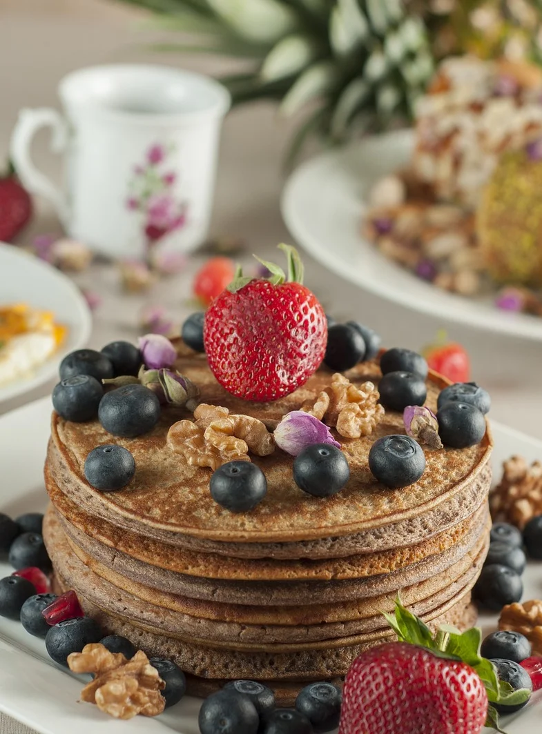 Fluffy pancakes topped with berries and walnuts