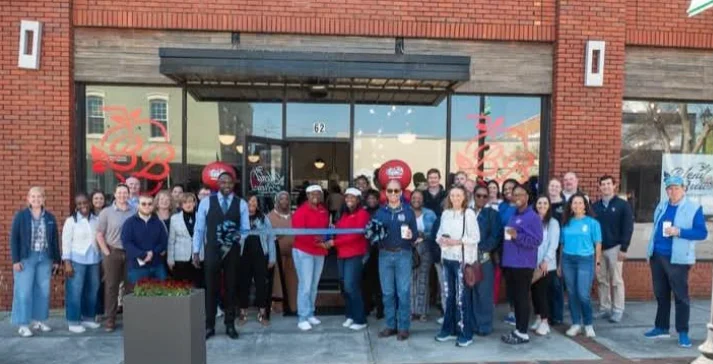 A festive ribbon cutting ceremony at a restaurant opening.