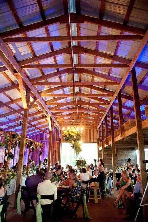 Elegant rustic dining setup in a barn with floral decorations