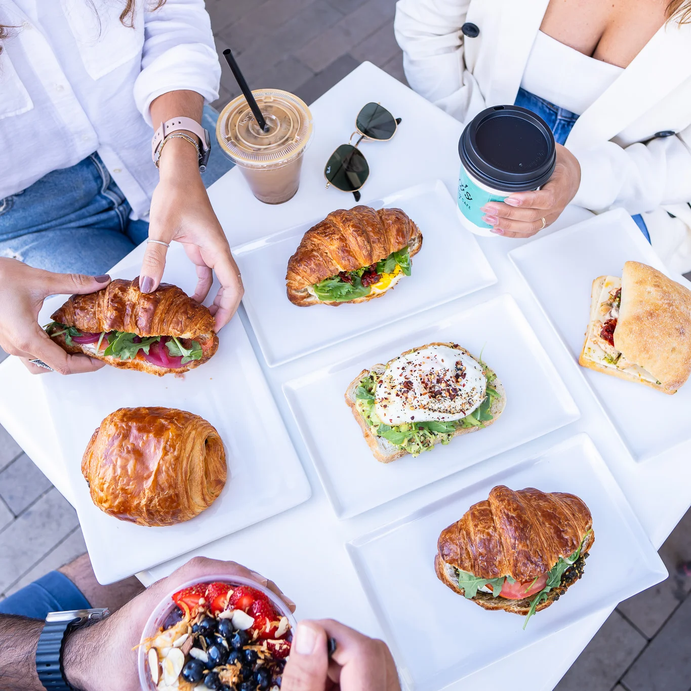 Assorted gourmet croissants and coffee on a sunny outdoor table