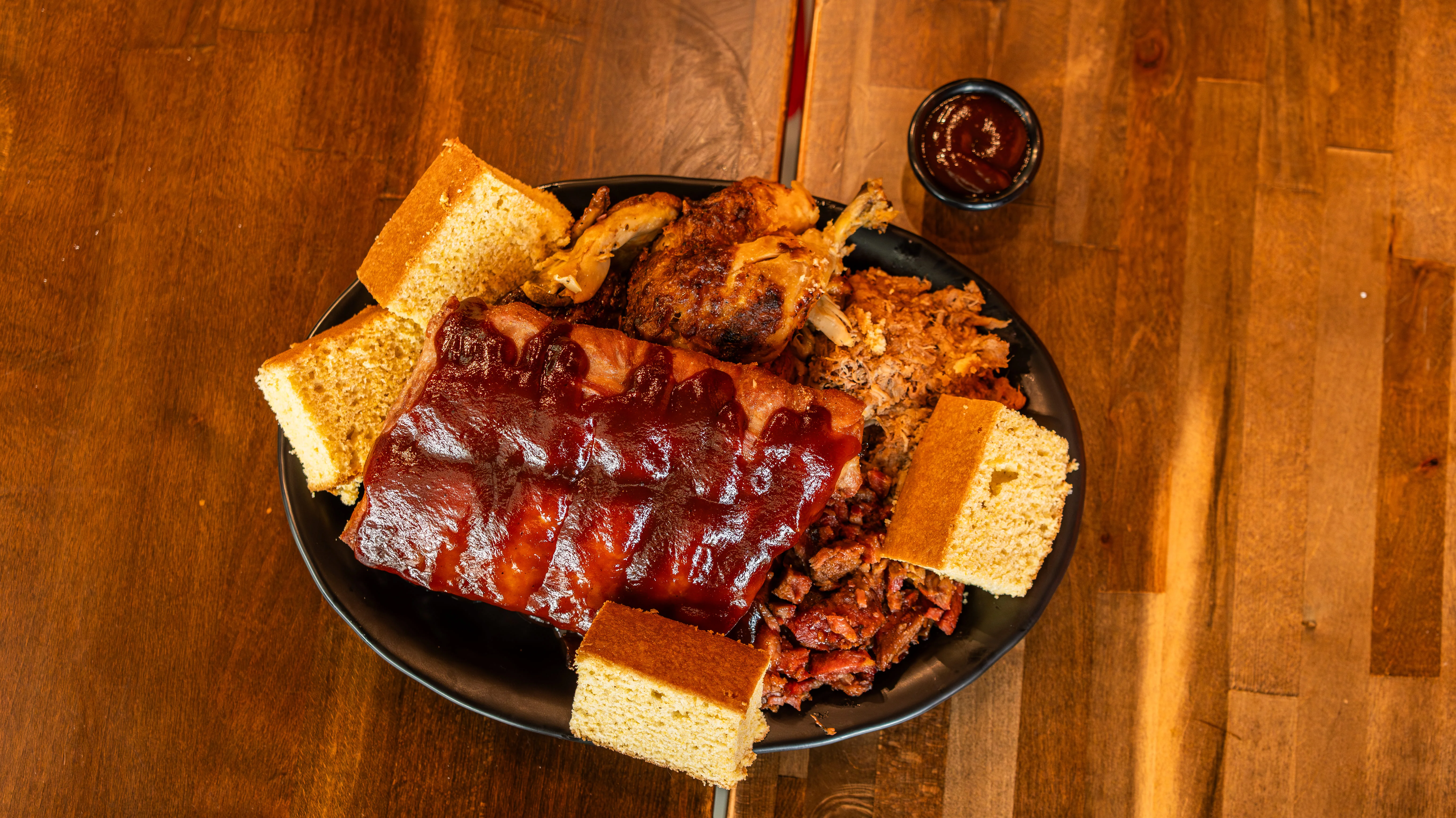 Platter of American barbecue ribs, chicken, and cornbread