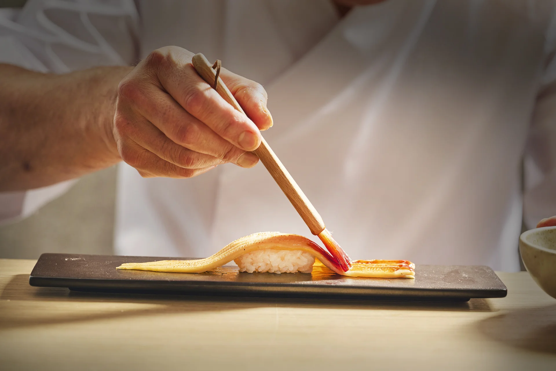 Japanese sushi chef preparing nigiri with precision