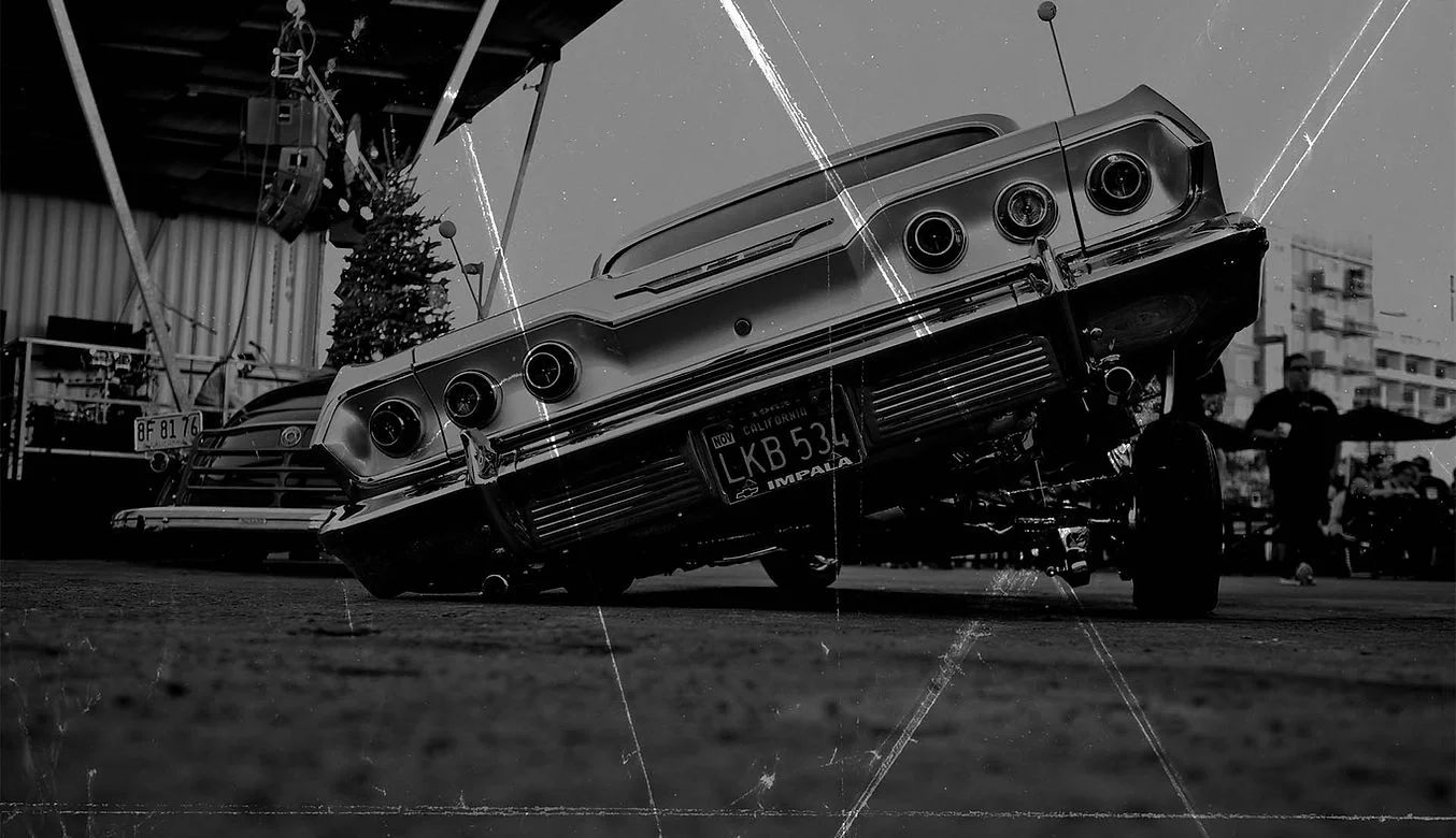 Classic lowrider car with a unique stance at an outdoor event