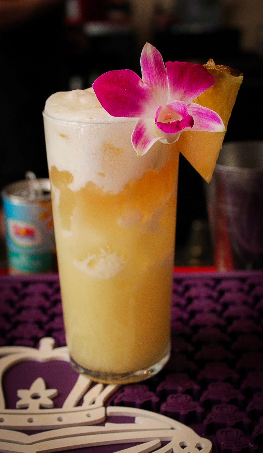 Tropical cocktail garnished with orchid and pineapple