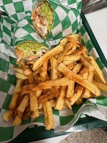 Crispy fish wrap with fries in a casual dining setting
