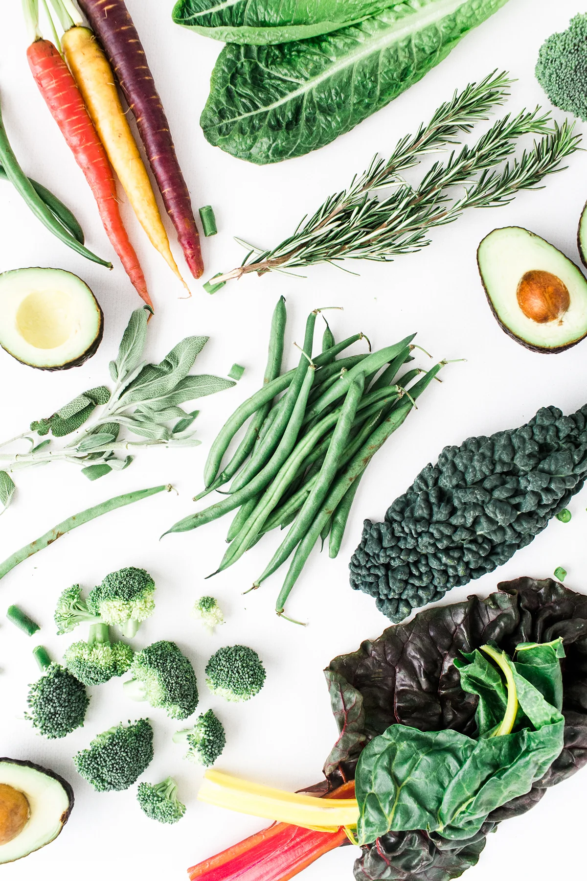 An assortment of fresh vegetables including carrots, greens, and herbs.
