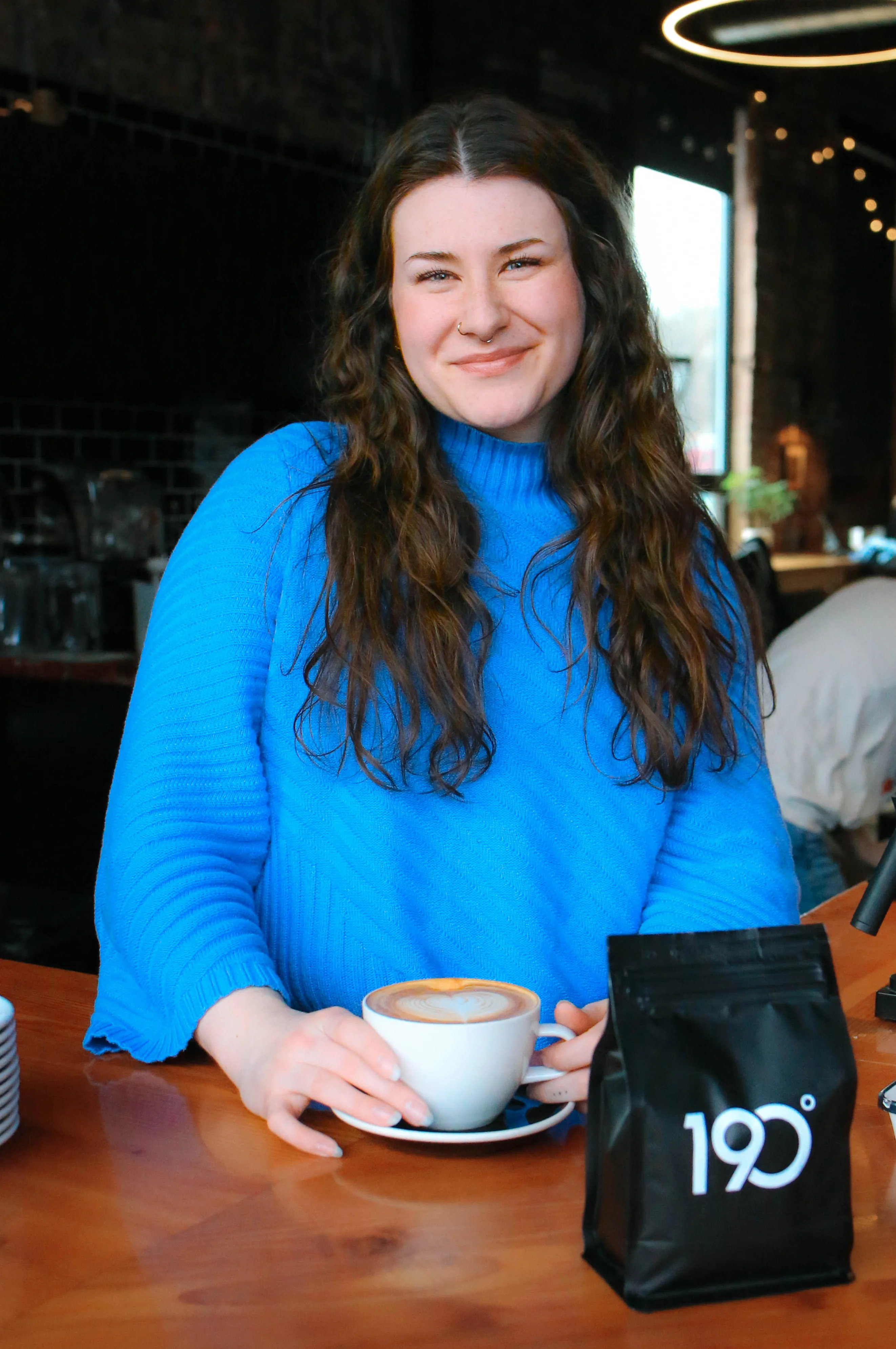 Barista serving a latte in a cozy café setting