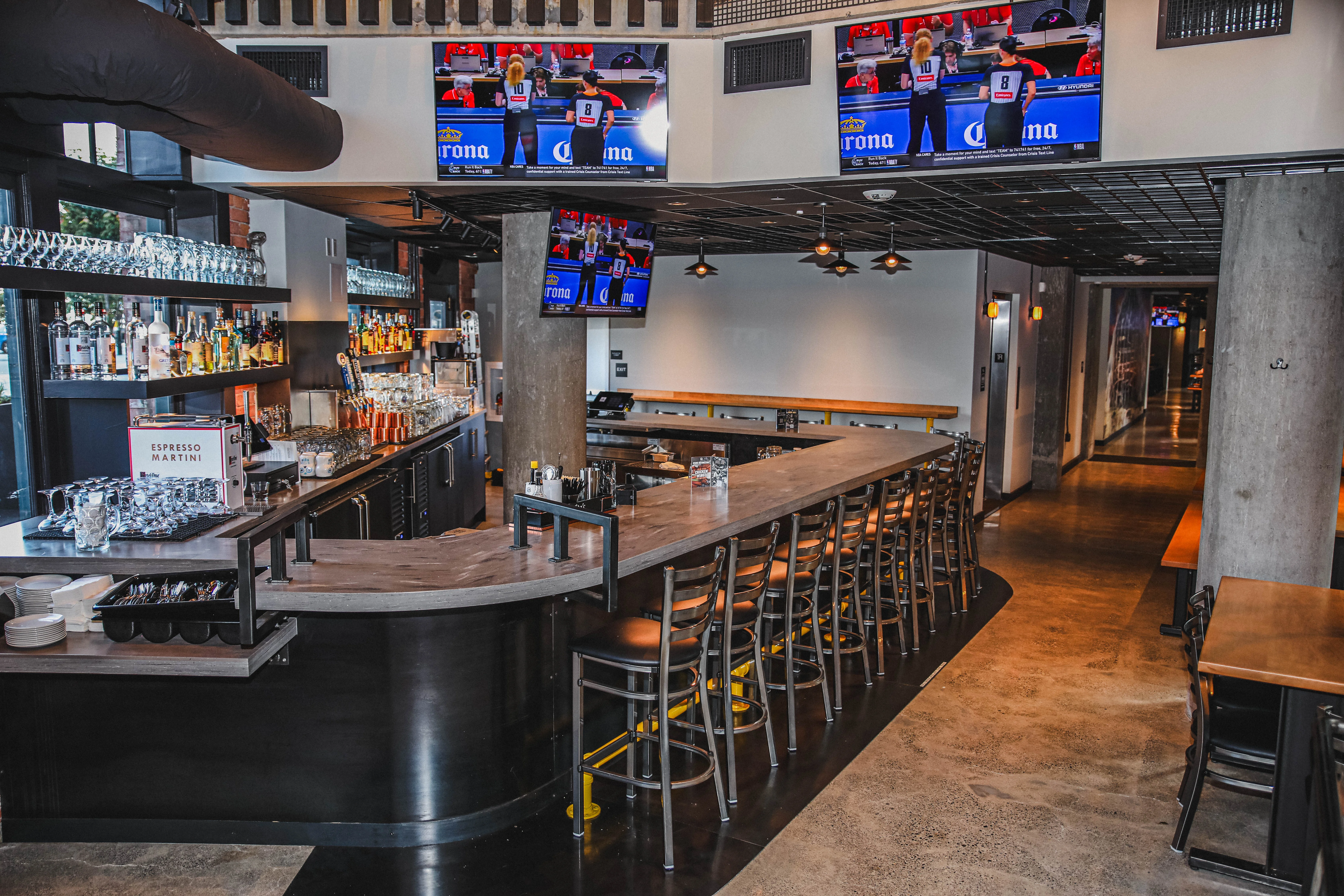 Modern bar interior with sleek design and multiple TVs