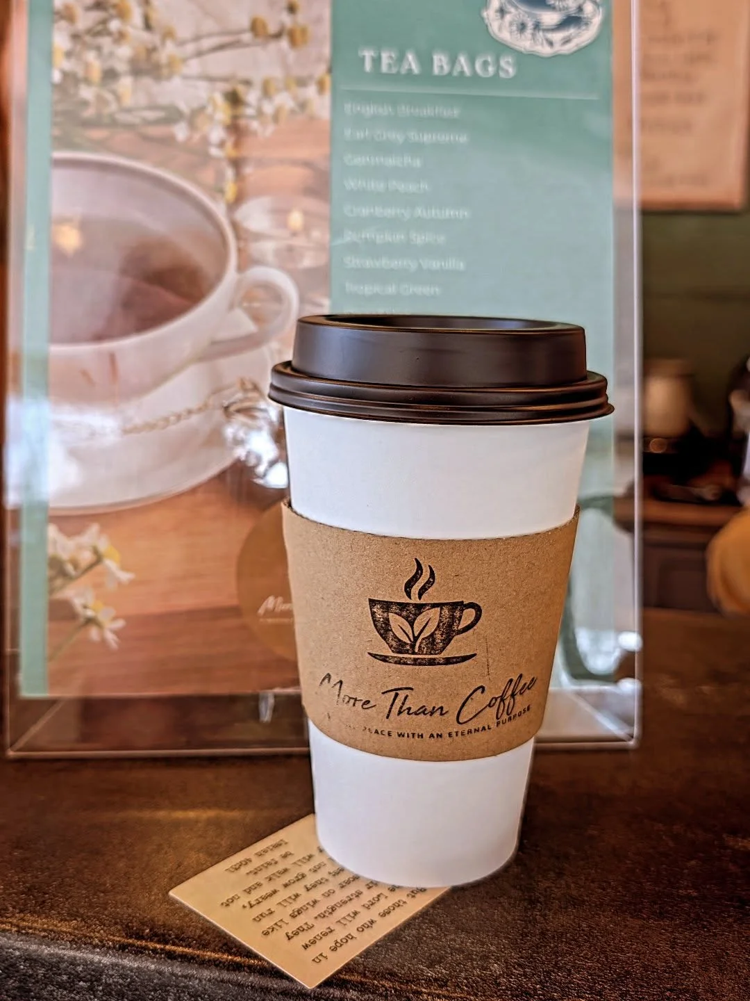 Coffee cup from More Than Coffee café with tea menu in background