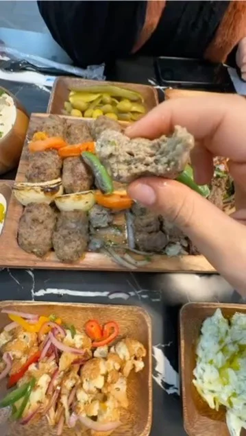 Grilled kebabs served with vegetables in a Middle Eastern platter