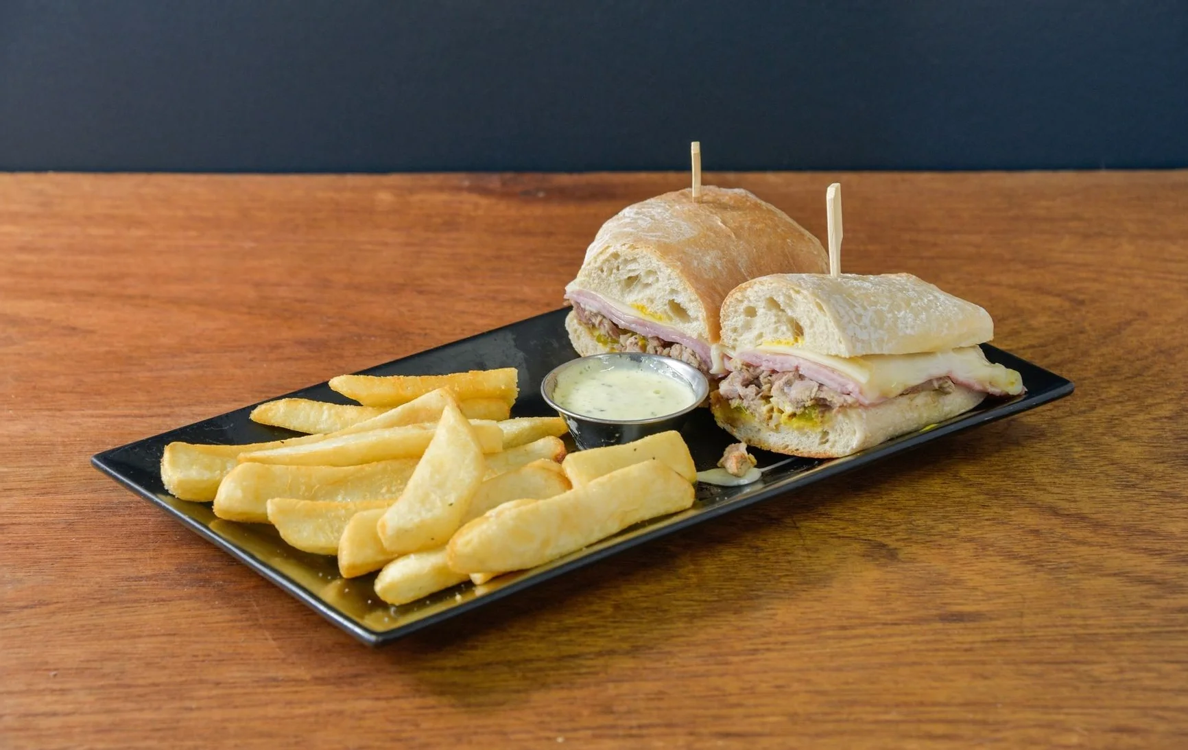 A delicious Cuban sandwich with layers of meat and pickles on toasted bread.