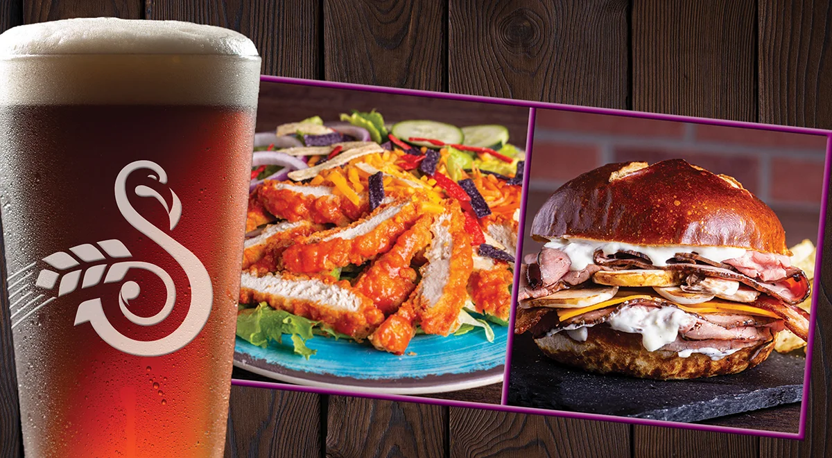 A frothy beer with buffalo chicken strips on mixed greens and a roast beef sandwich with bacon, ikeys sauce, mushrooms and cheddar cheese on a pretzel roll.