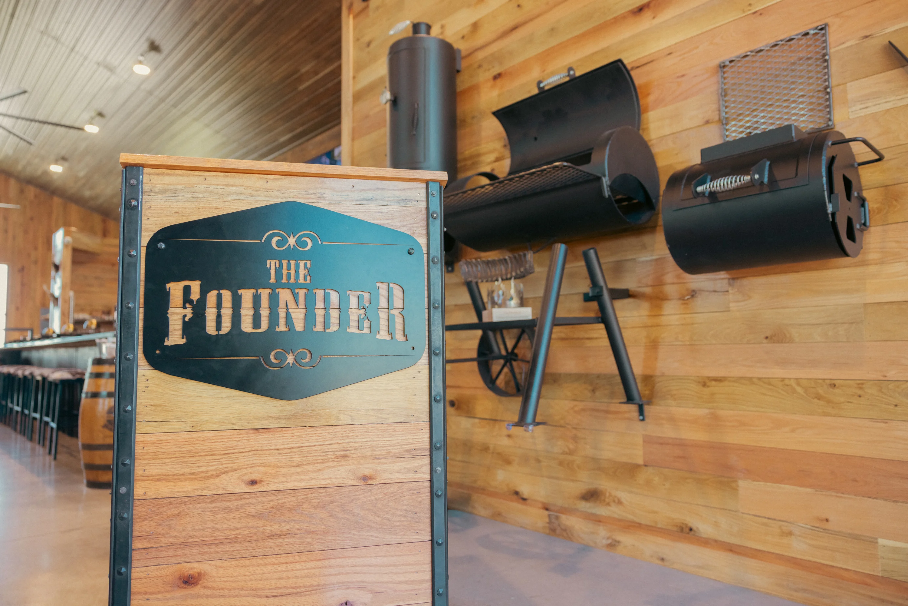 Interior view of The Founder restaurant with wooden decor and grills.