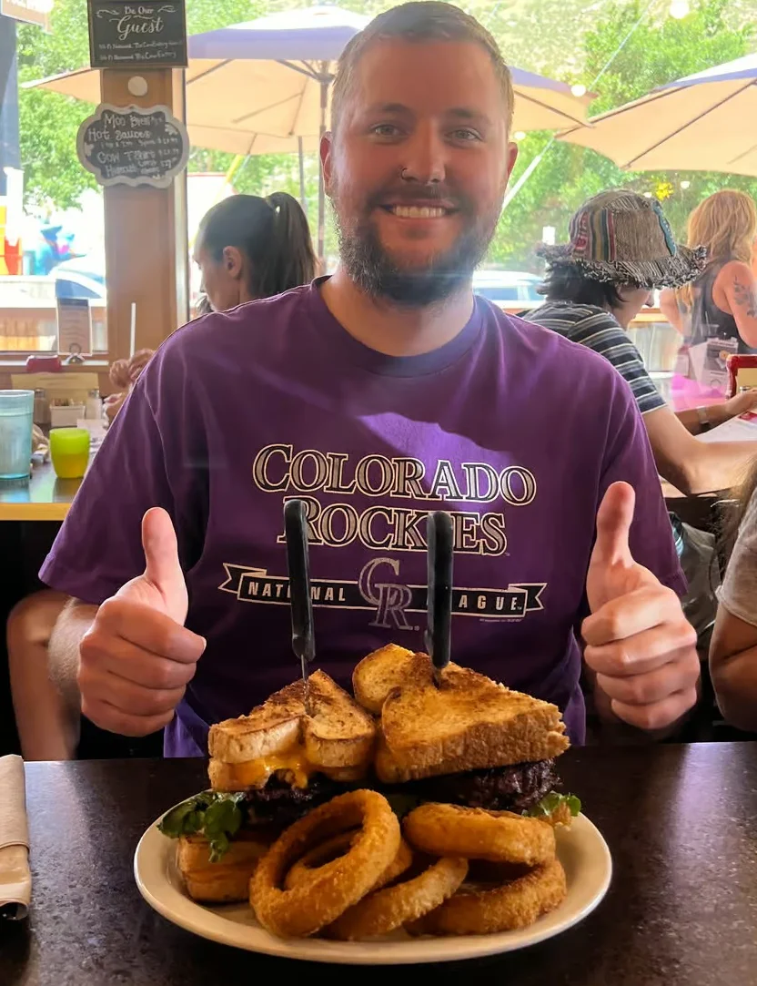 Giant burger with onion rings in a casual restaurant setting