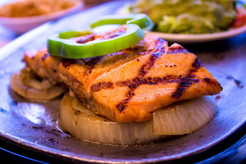 Grilled salmon fajitas served on a sizzling platter