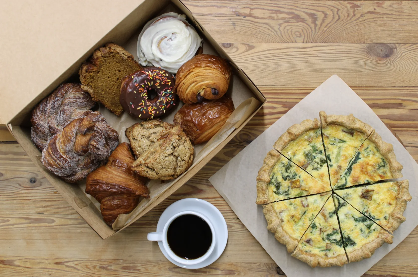 Assorted pastries and quiche on a wooden table