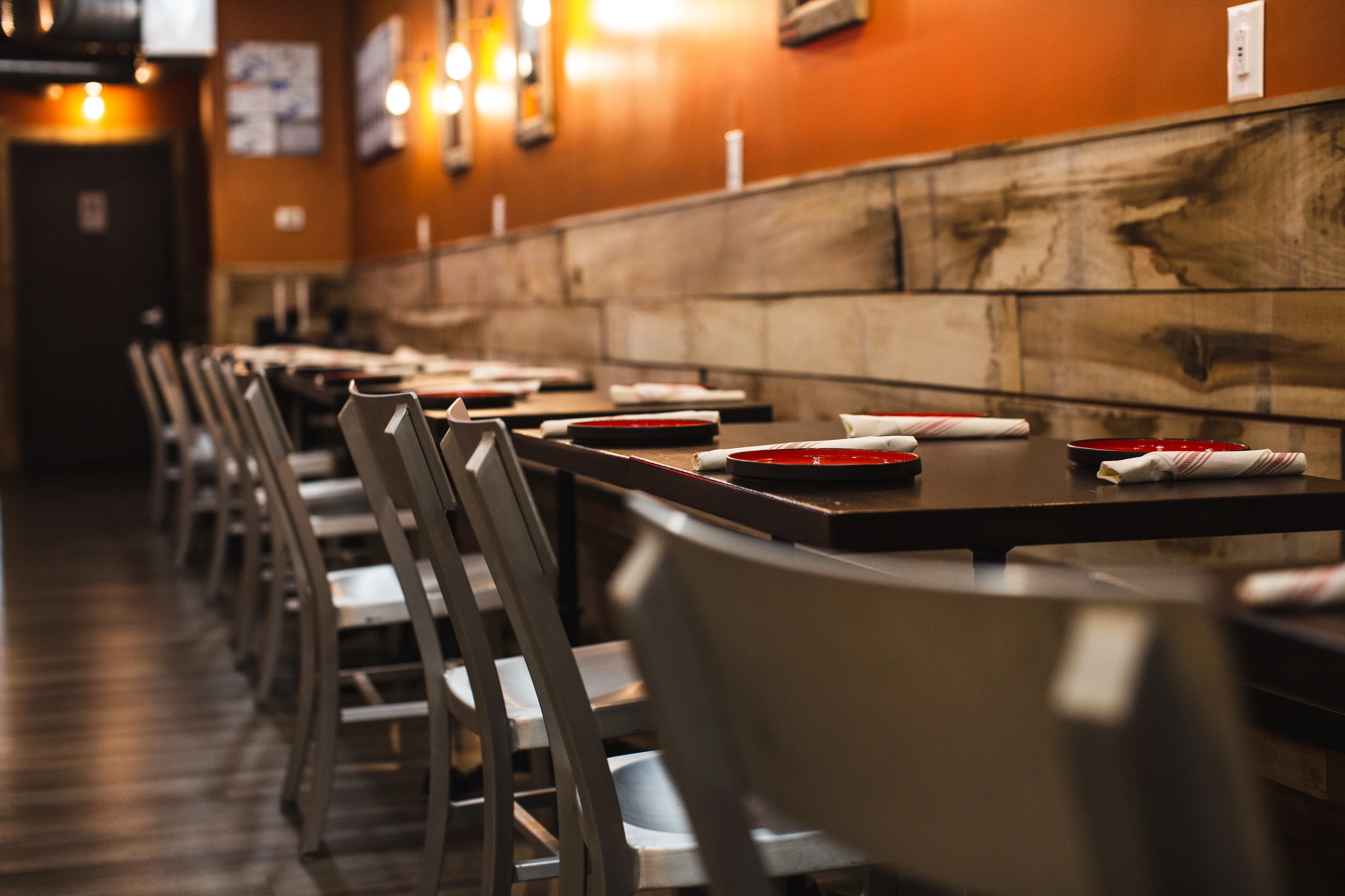 Cozy restaurant interior with wooden accents and red plates