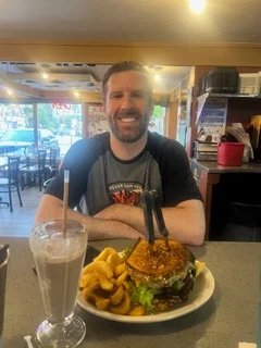 Juicy cheeseburger with curly fries in a casual diner setting
