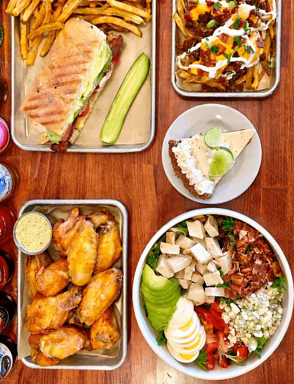 Platter of American comfort food: wings, sandwich, fries, salad, and key lime pie