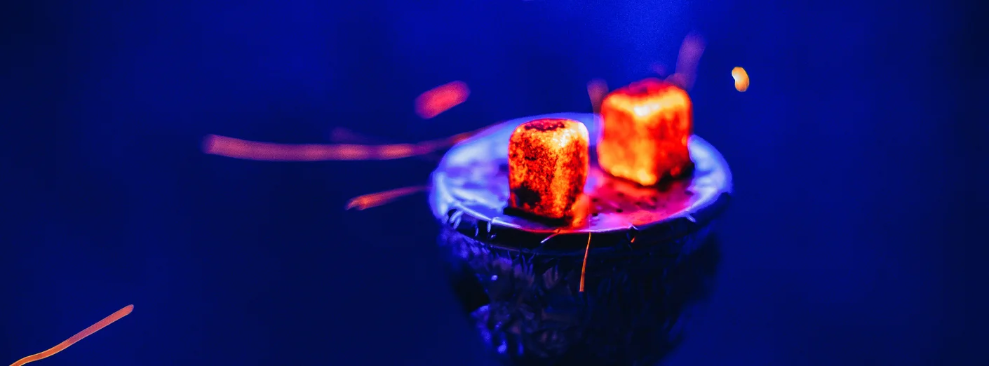 Glowing charcoal on a hookah bowl with blue background