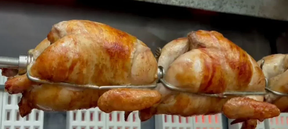 Rotisserie chicken cooking on a spit