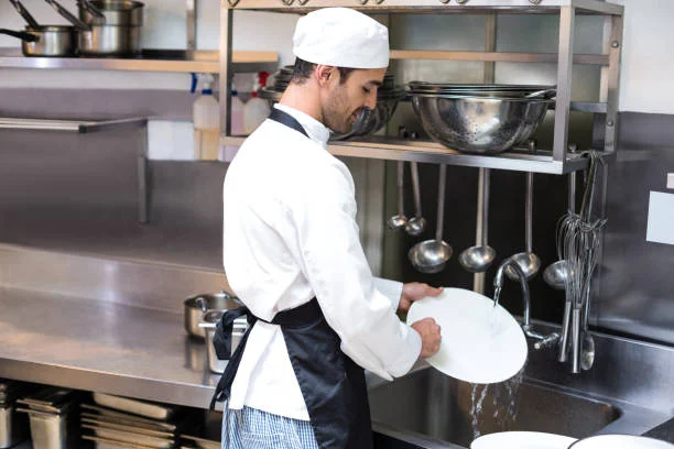 Chef washing dishes in a professional kitchen