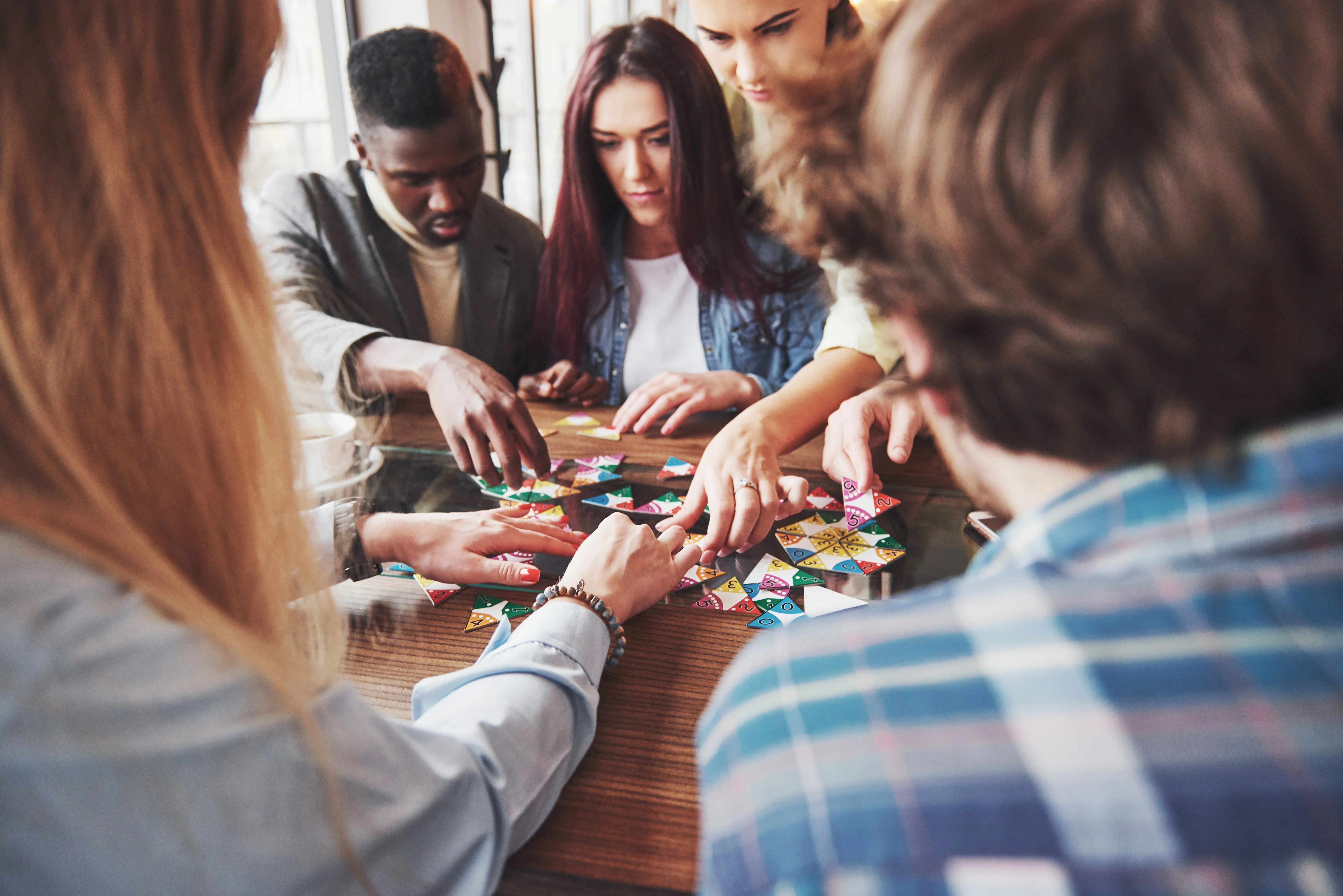 Group of friends playing a colorful board game at a cafe