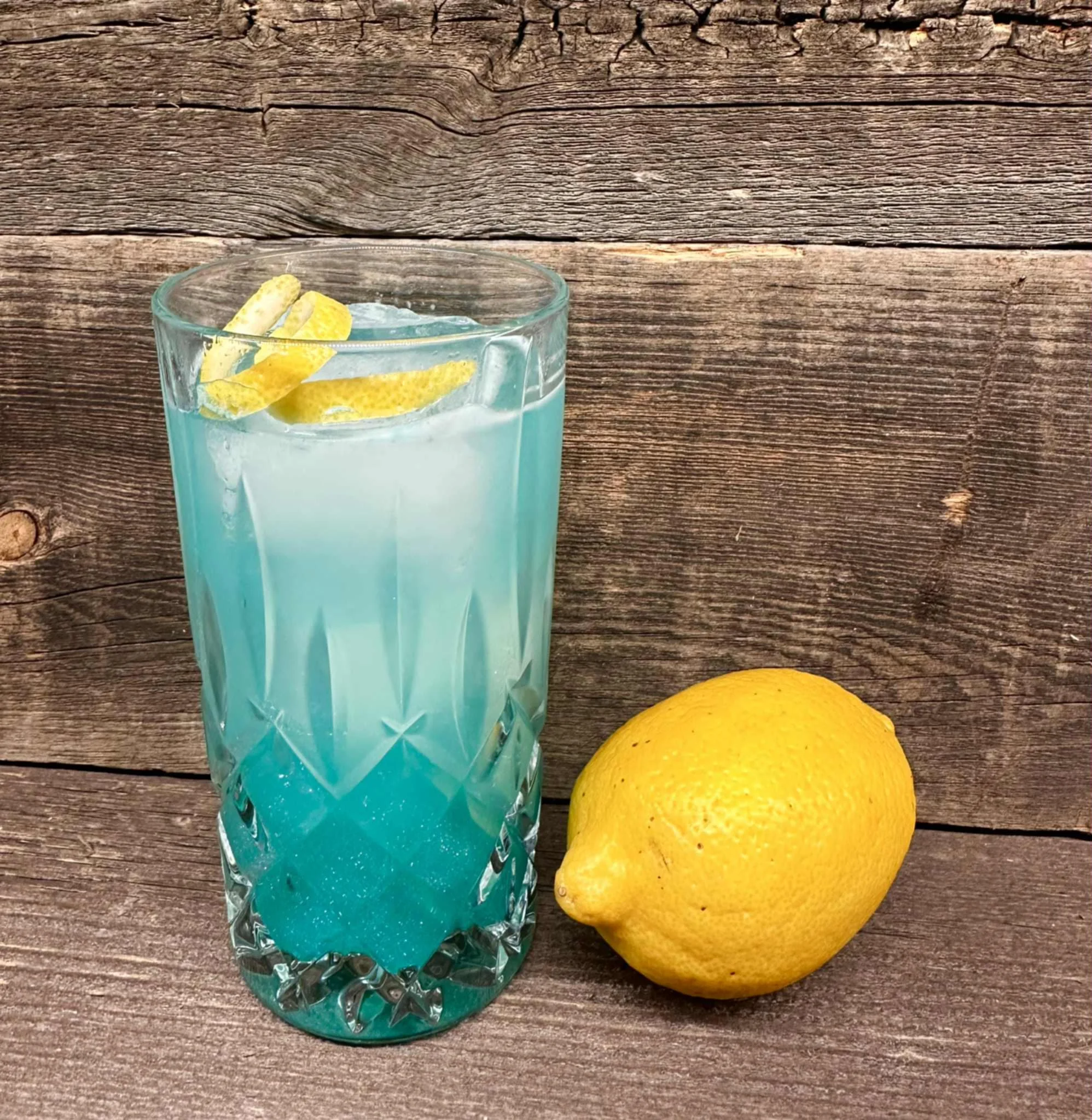 Refreshing blue cocktail with lemon garnish