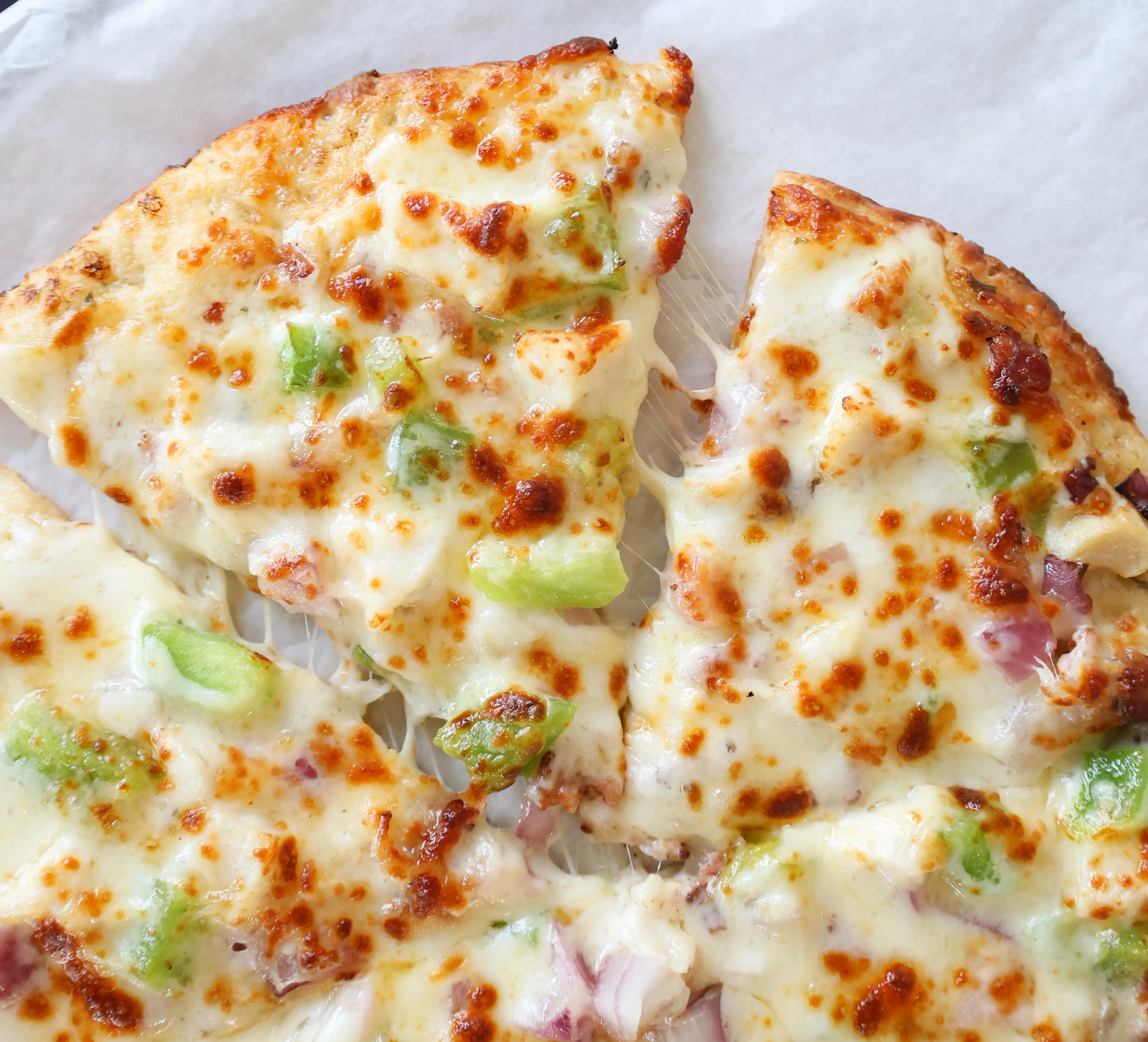 Savor the mouthwatering delight of Village Pizza's exclusive Chicken Bacon Ranch specialty, brimming with savory toppings and bursting with flavor, a must-try for pizza aficionados.