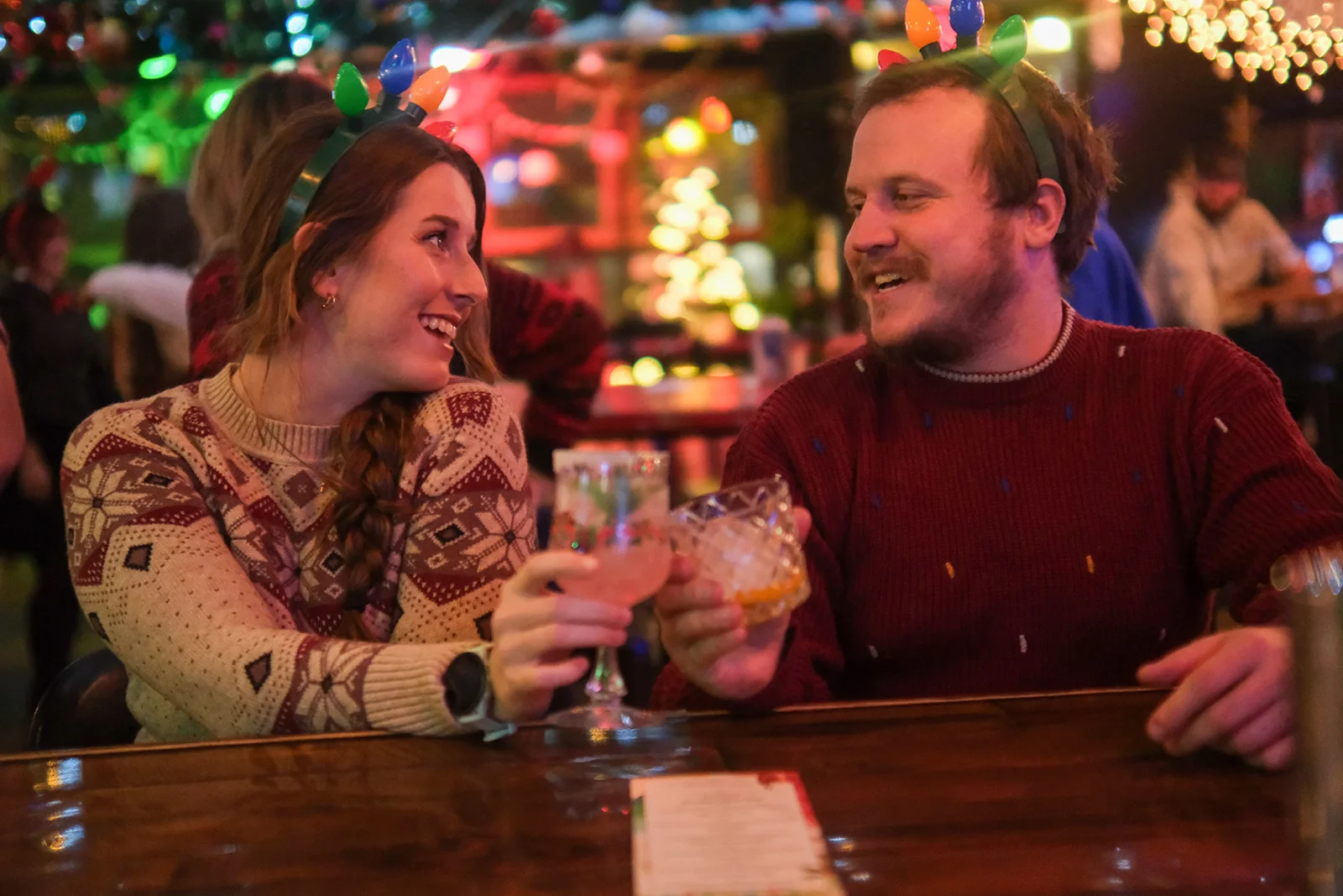 Friends toasting drinks in a festive bar setting